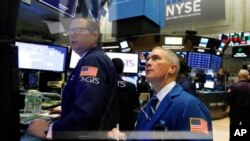 Los especialistas Gregg Maloney y Timothy Nick trabajan en el piso de la Bolsa de Nueva York, el 24 de octubre de 2018.