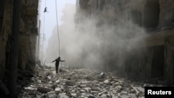 បុរស​ម្នាក់​ដើរ​កាត់​កម្ទេច​អគារ​បន្ទាប់​ពីមាន​ការ​វាយ​ប្រហារ​តាម​អាកាស​ទៅ​លើ​តំបន់​ដែល​កាប់​កាប់​ដោយ​ពួក​ឧទ្ទាម​នៅ​ជិត​ក្រុង​ Aleppo កាល​ពី​ថ្ងៃទី​២៥ ខែកញ្ញា ឆ្នាំ២០១៥។