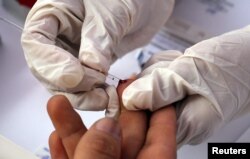 A nurse takes blood for a free HIV test during a HIV prevention campaign marking the World AIDS Day in Lima, Peru Dec. 1, 2016.