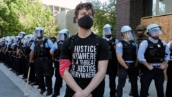 A demonstrator stands in front of Chicago Police officers during the March for Justice in honor of George Floyd Saturday, June 6, 2020, in Chicago. Demonstrators who gathered at Union Park marched through the city's West Side on Saturday afternoon,…
