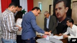 In this photo released by the Syrian official news agency SANA, Syrians cast their votes at a polling station during municipal elections in Damascus, Sept 16, 2018.