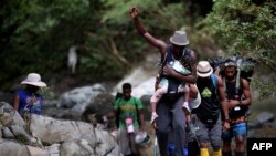 Migrantes haitianos cruzan la selva del Darién, cerca de Acandi, departamento de Chocó, Colombia, rumbo a Panamá, el 26 de septiembre de 2021.