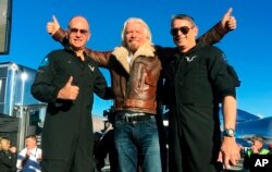 Richard Branson center celebrates with pilots Rick “CJ” Sturckow (L), and Mark “Forger” Stucky (R), after Virgin Galactic’s tourism spaceship climbed more than 50 miles high above California’s Mojave Desert on Dec. 13, 2018.
