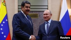 FILE - Russian President Vladimir Putin, right, shakes hands with his Venezuelan counterpart Nicolas Maduro during a meeting at the Novo-Ogaryovo state residence outside Moscow, Dec. 5, 2018.