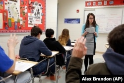 Students hold their hands up as Katerina Maylock, with Capitals Educators, teaches a test preparation class at Holton Arms School in Bethesda, Maryland.