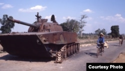 សំណល់​រថក្រោះ​ ដែល​ខូច​ដោយ​សង្គ្រាម​ ត្រូវ​គេ​ទុក​ចោល​ តាម​ដងច​ផ្លូវ​ចូល​មកកាន់​រាជធានី​ភ្នំពេញ​នាឆ្នាំ​១៩៨០។​ ​(រូប​ផ្តល់​ឱ្យ​ដោយ​លោក​ John Burgess)​