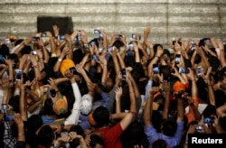 Supporters of Indian Prime Minister Narendra Modi use their mobile phones to take his picture as he addresses them after the election results at the Bharatiya Janata Party (BJP) headquarter in New Delhi, India, May 23, 2019.