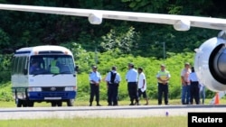 រូប​ឯកសារ៖ ជន​ភៀសខ្លួន​​​ដែល​ស្វះស្វែង​រក​សិទ្ធិ​ជ្រក​កោណ​កំពុង​ត្រូវ​គេ​នាំ​​ពី​យន្តហោះ​ទៅ​កាន់​​រថយន្ត​ក្រុង​នៅ​ក្រោយ​ពួក​គេ​ទើប​មក​ដល់​កោះ​ណូរូ​កាល​ពី​ថ្ងៃ​ទី​១៤ ខែ​កញ្ញា ឆ្នាំ​២០១២។