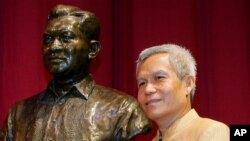 លោក​ Sombath Somphone មកពី​ប្រទេសឡាវ​ ដែល​ជាជ័យ​លាភីទទួល​ពានរង្វាន់​ Ramon Magsaysay សម្រាប់​ភាពជា​អ្នក​ដឹកនាំ​សហគមន៍​ក្នុងឆ្នាំ២០០៥​ ថតរូបជា​មួយ​រូបសំណាក​អតីត​ប្រធានាធិបតី​ហ្វីលីពីន​ ថ្ងៃទី៣១​ ខែសីហា​ ឆ្នាំ២០០៥។ 