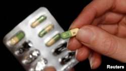 FILE - A woman holds a packet of the antidepressant drug Prozac, also known as fluoxetine.