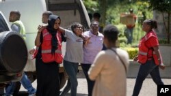 Ndugu wa mmoja wa wale walioathiriwa na shambulizi la kigaidi akisindikizwa na wafanyakazi wa Msalaba Mwekundu akiwa na majonzi baada ya kwenda kwenye chumba cha kuhifadhi maiti jijini Nairobi, Kenya Alhamisi, Jan. 17, 2019. 