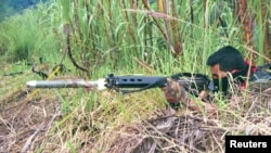 Un rebelde de izquierda del Ejército de Liberación Nacional (ELN) prueba su arma durante un ejercicio de entrenamiento cerca de las montañas de la ciudad de Tibu, provincia de Norte de Santander. [Foto de archivo]