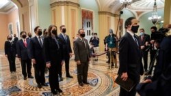 FILE - Democratic House impeachment managers stand before entering the Senate Chamber as they deliver to the Senate the article of impeachment alleging incitement of insurrection against former President Donald Trump, in Washington, Jan. 25, 2021.