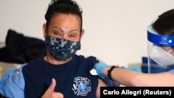 Seorang pekerja dari Biro Layanan Darurat Medis, Departemen Pemadam Kebakaran Kota New York, menerima vaksinasi vaksin Covid-19 buatan Moderna, di Manhattan, Kota New York, New York, Rabu, 23 Desember 2020. (Foto: Carlo Allegri/Reuters)