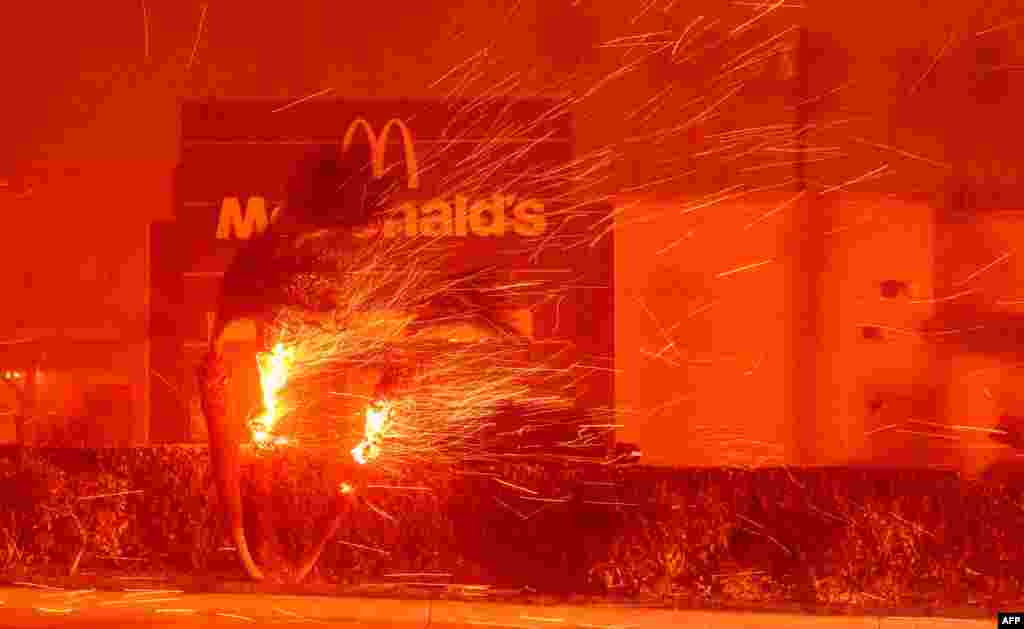 A McDonald's restaurant is showered in embers during the Eaton Fire in Pasadena, California, Jan. 7, 2025.&nbsp;A ferocious wildfire in a Los Angeles suburb devoured buildings and sparked panicked evacuations, as hurricane-force winds tore through the region. More than 200 acres (80 hectares) was burning in Pacific Palisades, a upscale spot with multi-million dollar homes in the Santa Monica Mountains. Across town, on the northern edge of Los Angeles, another fire broke out in Eaton Canyon, near Pasadena, quickly consuming 200 acres (81 hectares) later in the night, according to Angeles National Forest officials.