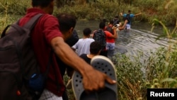 Migrantes, en su mayoría de Venezuela, cruzan el río Bravo con la intención de entregarse a los agentes de la Patrulla Fronteriza de Estados Unidos, visto desde Ciudad Juárez, México, el 21 de septiembre de 2023.