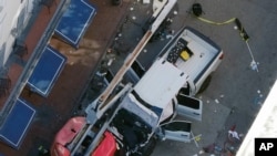 Una bandera negra con letras blancas yace en el suelo enrollada detrás de una camioneta que un hombre arrojó contra una multitud en Bourbon Street en Nueva Orleans, matando e hiriendo a varias personas, la madrugada del miércoles 1 de enero de 2025. AP