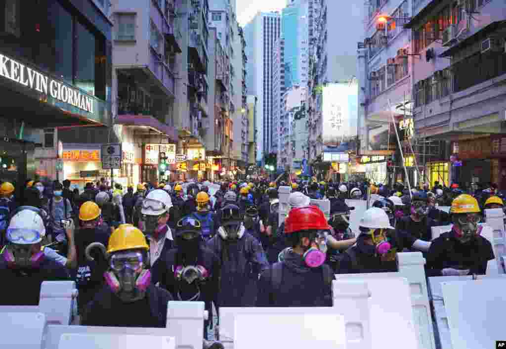 Manifestantes con equipo de protección se reúnen en Central, el principal distrito financiero de Hong Kong, el domingo 8 de septiembre de 2019, en una marcha pacífica al Consulado de EE.UU., para pedir al presidente Donald Trump "liberar" el territorio chino semiautónomo, pero la violencia estalló más tarde en Central después de que los manifestantes destrozaron las estaciones de metro, incendiaron y bloquearon el tráfico. (Foto AP / Kin Cheung)