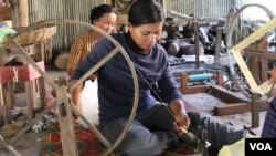 អ្នកស្រី រឿន លាន់ វ័យ៣០ឆ្នាំ កំពុងខាសូត្រ នៅអង្គការវិទ្យាស្ថានវាយនភណ្ឌប្រពៃណីខ្មែរ Institute of Khmer Traditional Textiles នៅក្នុងស្រុក អង្គរធំខេត្តសៀមរាប កាលពីថ្ងៃទី២១ ខែកក្កដា ឆ្នាំ២០២០។ (ផនបុប្ផា/វីអូអេ)