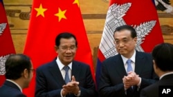 Cambodian Prime Minister Hun Sen, center left, applauds with Chinese Premier Li Keqiang during a signing ceremony at the Great Hall of the People in Beijing, China, Tuesday, Jan. 22, 2019. 