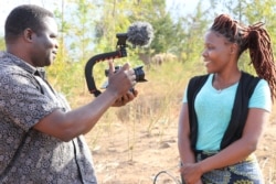 Malawian jounalist Eldson Chagara interviews a news source, Linda Alimoso. (Lameck Masina/VOA)