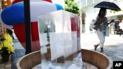 A block of ice is placed at a pedestrian street to cool down the spot in Tokyo Friday, July 20, 2018.