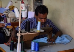 FILE - Rohingya refugee Muhammad Ayub sews clothes at a market in Kuala Lumpur, Malaysia, Aug. 15, 2016.