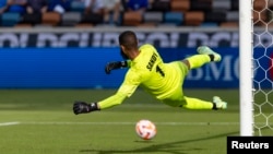 El arquero cubano Sandy Sanchez es sobrepasado por un disparo de penal del delantero canadiense Junior Hoilett (10) en la primera mitad del partido en el Shell Energy Stadium de Houston, Texas, EEUU el 4 de julio de 2023. 