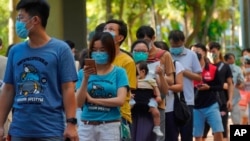 People queue up to vote in Hong Kong Sunday, July 12, 2020, in an unofficial primary for pro-democracy candidates ahead of legislative elections in September. Over 200,000 Hong Kongers voted in an unofficial Hong Kong primary that will help the pro…
