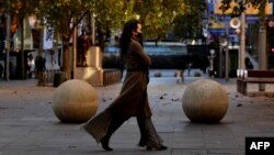 Žena nosi masku dok šeta Sidnejom, 25. juni 2021.