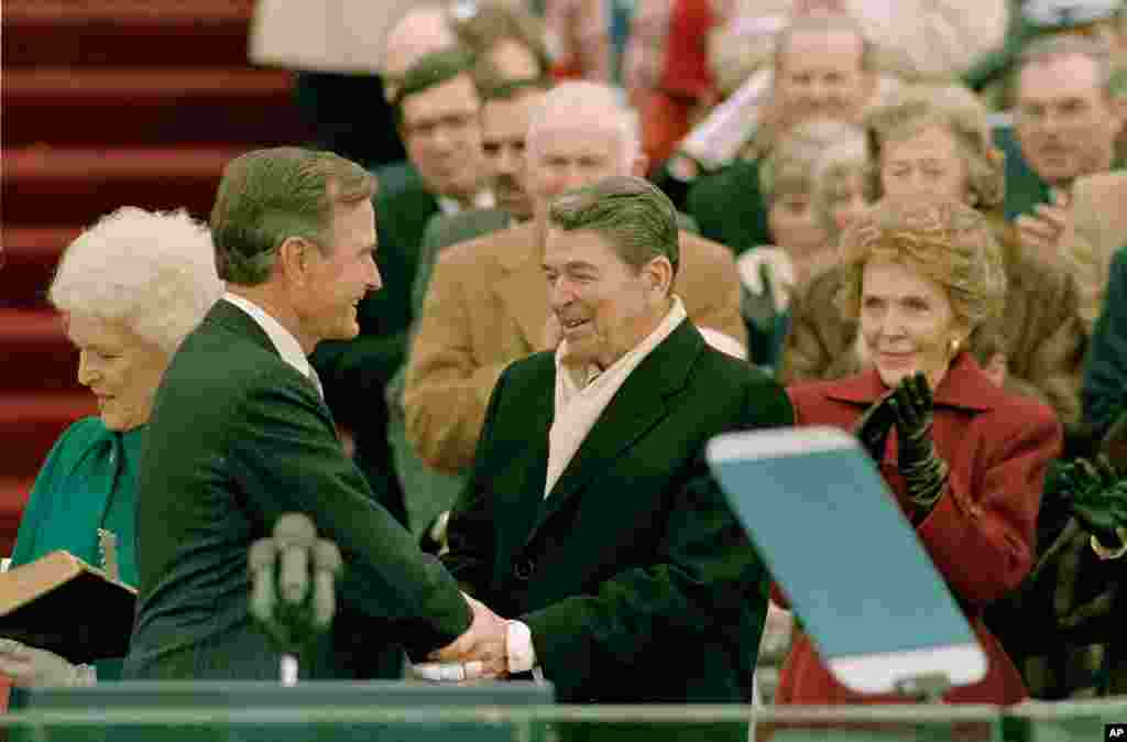 President George Bush (left) is congratulated by outgoing President Ronald Reagan after Bush took the oath of office as the 41st president of the United States on Capitol Hill in Washington, D.C., Jan. 20, 1989.