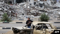 ፍልስጤማዊ ታዳጊ በማዕከላዊ ጋዛ ሰርጥ ቡሬጅ የስደተኞች መጠላያ ጣቢያ ውስጥ በጦርነት ባወደመ ተሽከርካሪ አጠገብ ቆሞ ይታያል፤ እአአ የካቲት 7 ቀን 2025