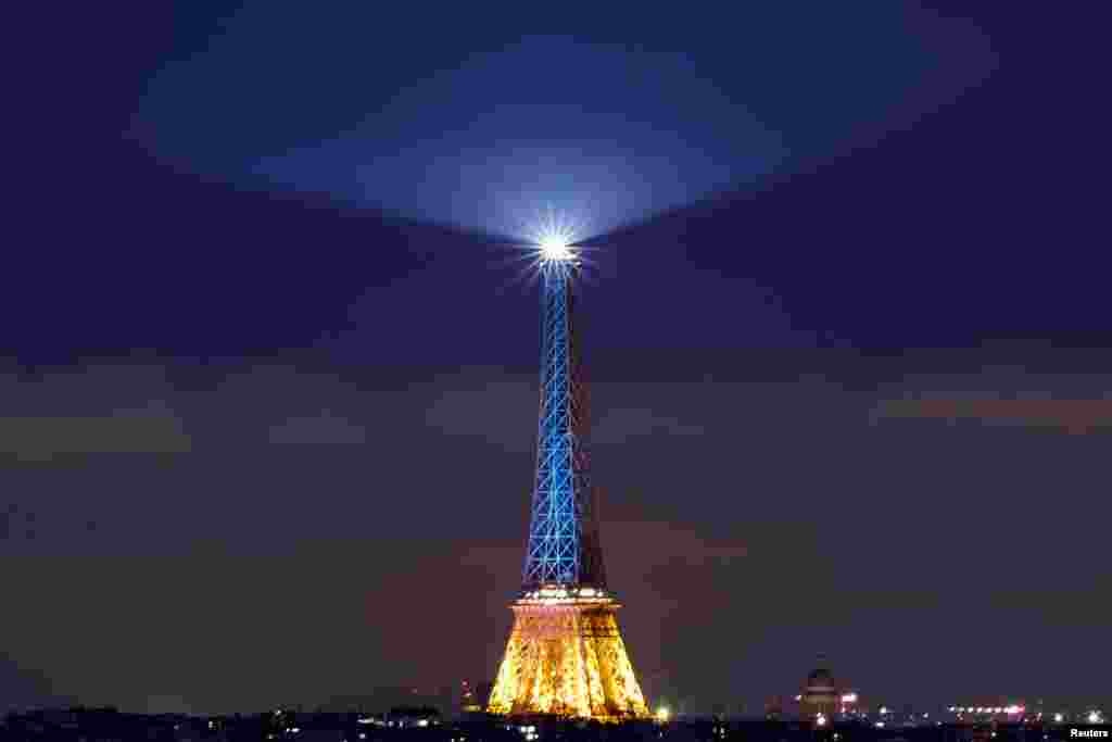 The Eiffel Tower is lit up in blue and yellow, the national colors of Ukraine, to mark the third anniversary of Russia's invasion of Ukraine, in Paris, France.
