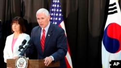 El vicepresidente estadounidense, Mike Pence, habla mientras su esposa Karen Pence escucha durante una cena con soldados y miembros de la familia después de los servicios religiosos del domingo de Pascua en una base militar en Seúl, Corea del Sur, domingo 16 de abril de 2017. 
