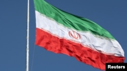 FILE - The Iranian flag is seen flying over a street in Tehran.