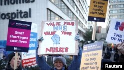 NHS nurses display signs at a strike, due to a dispute with the government over pay, outside St Thomas' Hospital in London, Britain Dec. 15, 2022. 