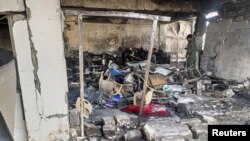 یکی از اعضای نیروهای امنیتی روز ۲۵ خرداد ۱۴۰۱ در حال بررسی ویرانی‌های به جا مانده از حملات هوایی در منطقه سنجار، عراق، است