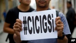 ARCHIVO - En esta foto del 20 de abril de 2015, un hombre sostiene un cartel con la leyenda "#CICIGSi" en referencia a la Comisión Internacional Contra la Impunidad en Guatemala (CICIG), durante una protesta contra el entonces presidente Otto Pérez Molina en Ciudad de Guatemala.