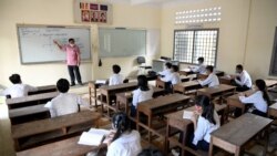 Students, seated in class while observing social distancing measures against the COVID-19 coronavirus, pay attention to their mask-clad teacher in Phnom Penh on September 7, 2020, as schools reopen across the country. (Photo by TANG CHHIN Sothy/AFP)