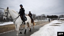 Policija na konjima prolazi pored sigurnosne ograde u Washingtonu, 18. januar 2025. (Foto: ANDREW CABALLERO-REYNOLDS/AFP)