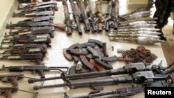 Weapons and ammunition seized from suspected members of Islamist rebel force Boko Haram are displayed during a military patrol in Hausari village, near Maiduguri, Nigeria, June 5, 2013.