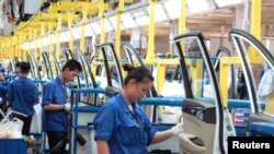 資料圖：在中國廣西壯族自治區柳州市的通用五菱汽車工，員工在一條生產線上工作。 (路透社2016年6月19日)