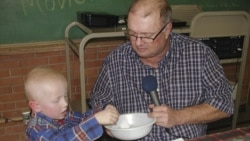 Eric Kuhlman, 3, helps master of cermonies Stan Miller draw names for the annual Norcatur drawing.