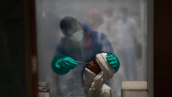 A health worker takes a nasal swab of a person for a COVID-19 test at a hospital in New Delhi, India, on July 6, 2020.