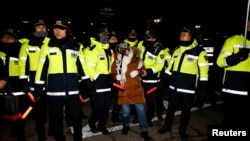 A woman reacts among police officers outside the National Assembly, after South Korean President Yoon Suk Yeol declared martial law, in Seoul, South Korea, December 4, 2024.