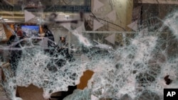 Bank employees are seen through the broken facade of Bank of Beirut that was smashed by anti-government protesters in Beirut, Lebanon, Jan. 15, 2020. 