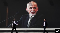 FILE - In this Aug. 14, 2021 file photo, a mural of Afghan President Ashraf Ghani hangs at Hamid Karzai International Airport, in Kabul, Afghanistan.