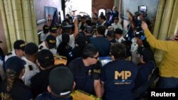 Miembros del Ministerio Público de Guatemala cargan cajas con boletas electorales durante un allanamento en el Supremo Tribunal Electoral en la Ciudad de Guatemala el 30 de septiembre de 2023.
