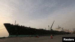 FILE - A cargo ship unloads a shipment of fuel at the Hodeida port, Yemen, May 27, 2018. 