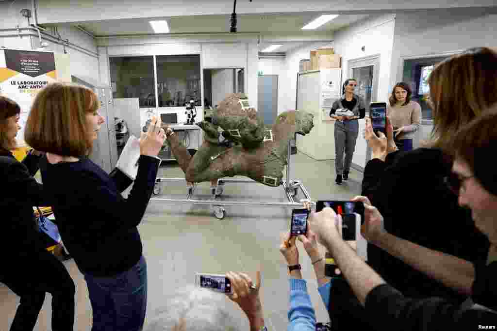 Journalists take pictures of the Reclining Vishnu, known as the "Mona Lisa of Cambodia" or the "Venus de Milo of Cambodia," from the West Mebon temple in Angkor during a press event for statue's restoration by the Center for Research and Restoration in French Museums&nbsp;at the Arc'Antique laboratory in Nantes, France.